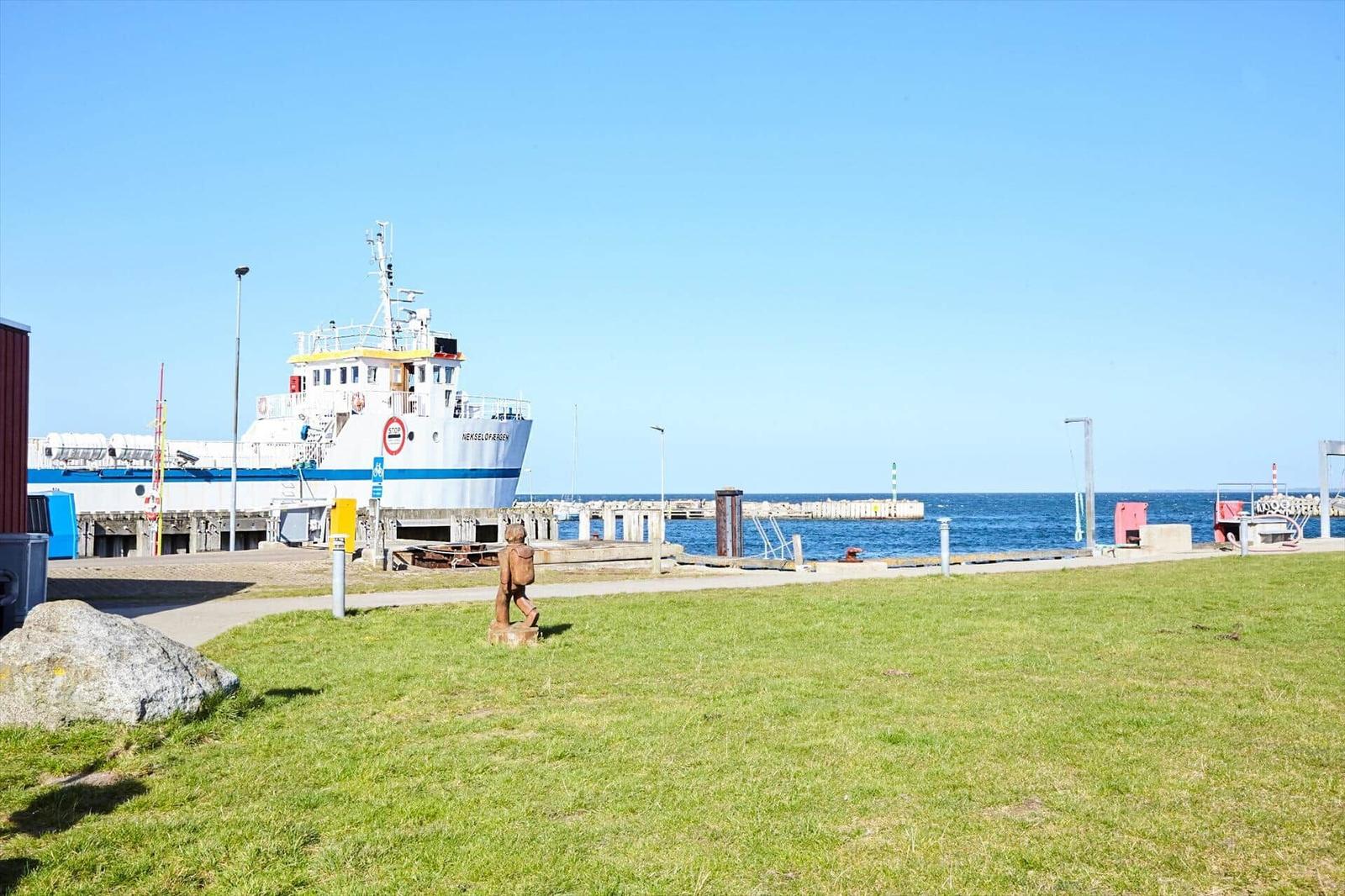 Harbor with fishing vessel and grassy area in the foreground.