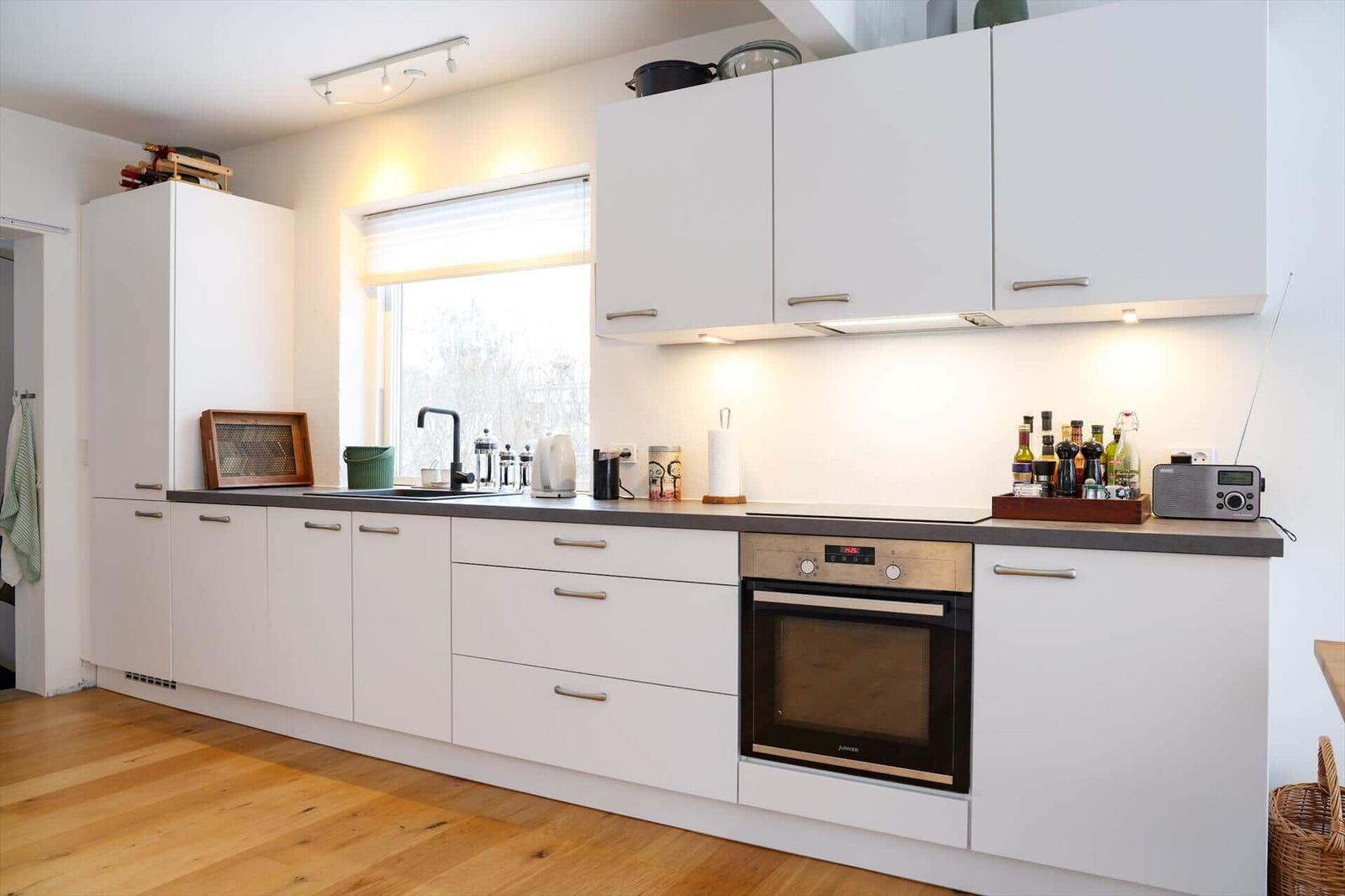 Kitchen with white cabinets, countertop, and built-in oven.