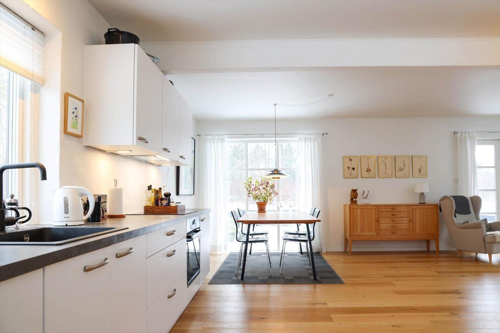 Kitchen with dining area and living room with hardwood floors and windows.