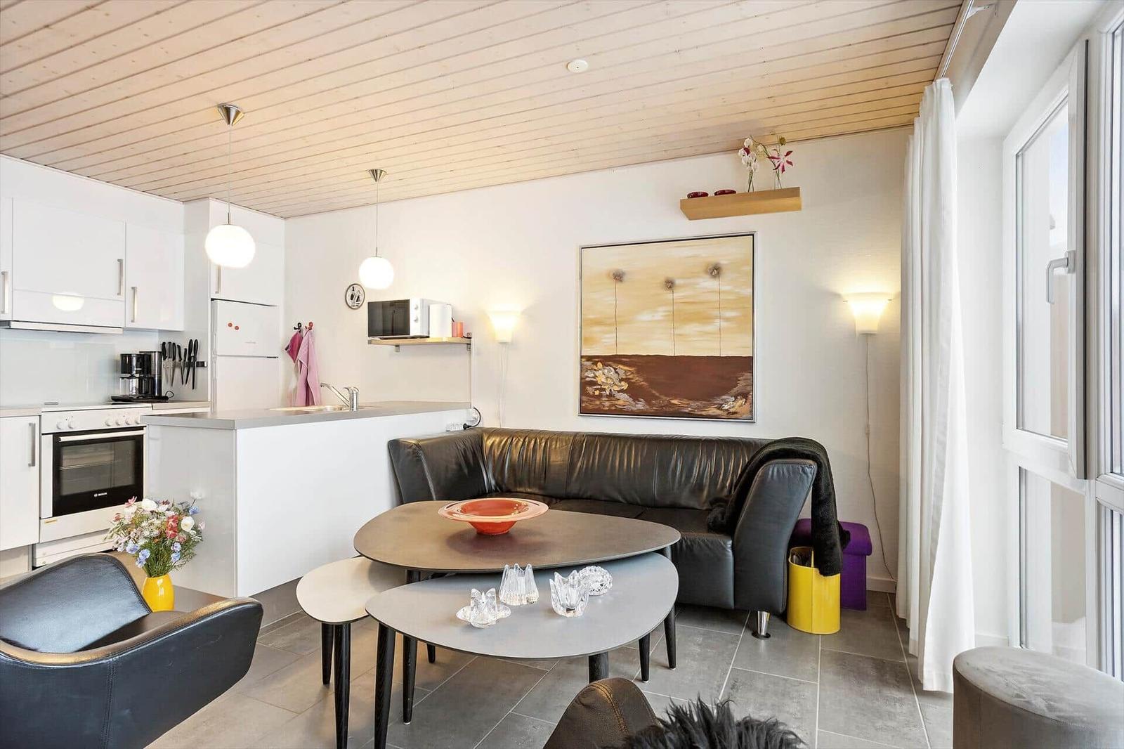 Living and kitchen area with sofa, table, and window.