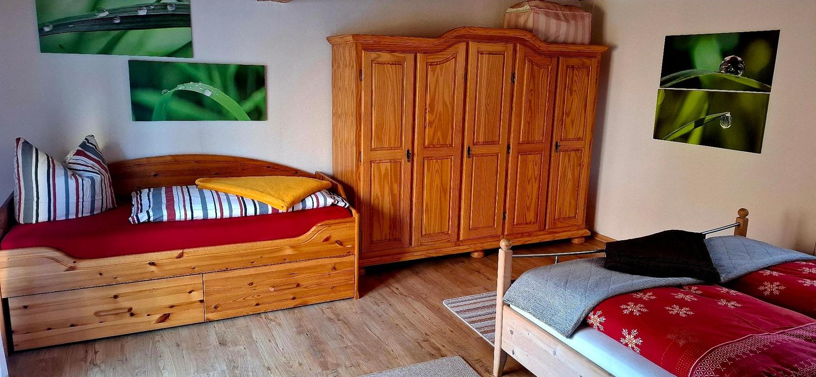 Zwei Betten und ein großer Holzschrank im Schlafzimmer.