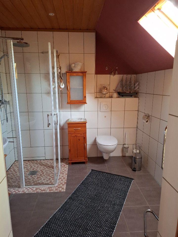 Bad mit Dusche, Toilette und Holzschrank unter Dachschräge