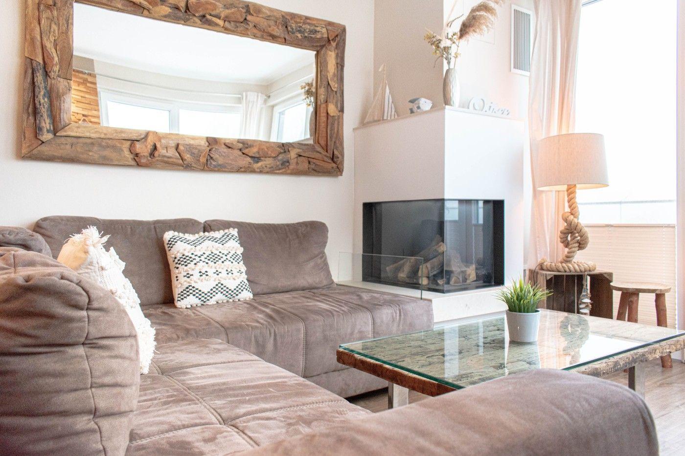 Wohnzimmer mit Sofa, Kamin und Glas-Tisch