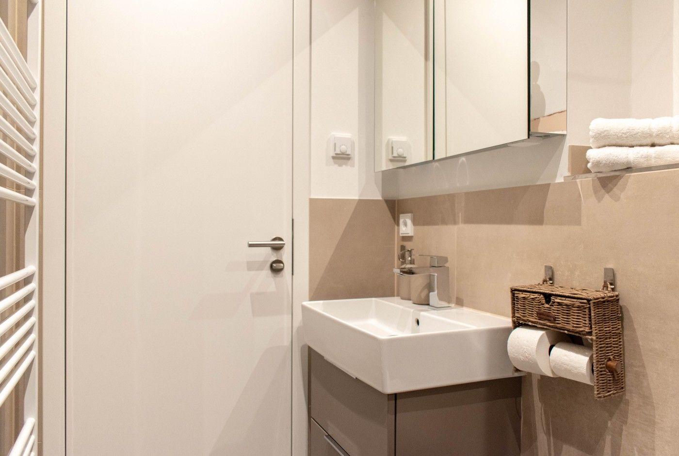 Badezimmer mit Waschbecken, Spiegel und Handtuchhalter