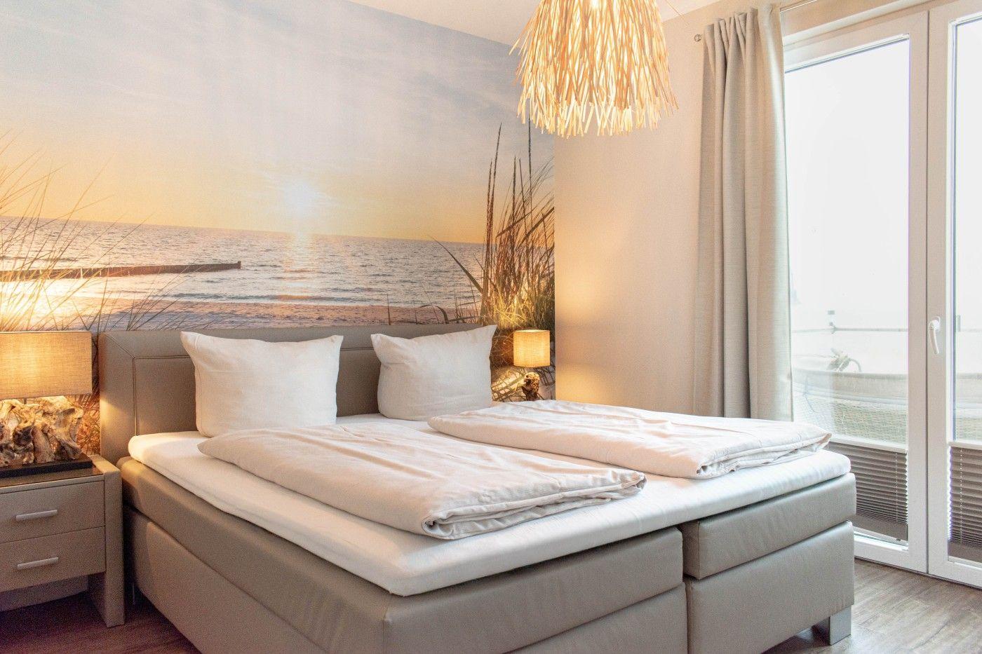 Schlafzimmer mit Bett, Wandbild und Balkontür