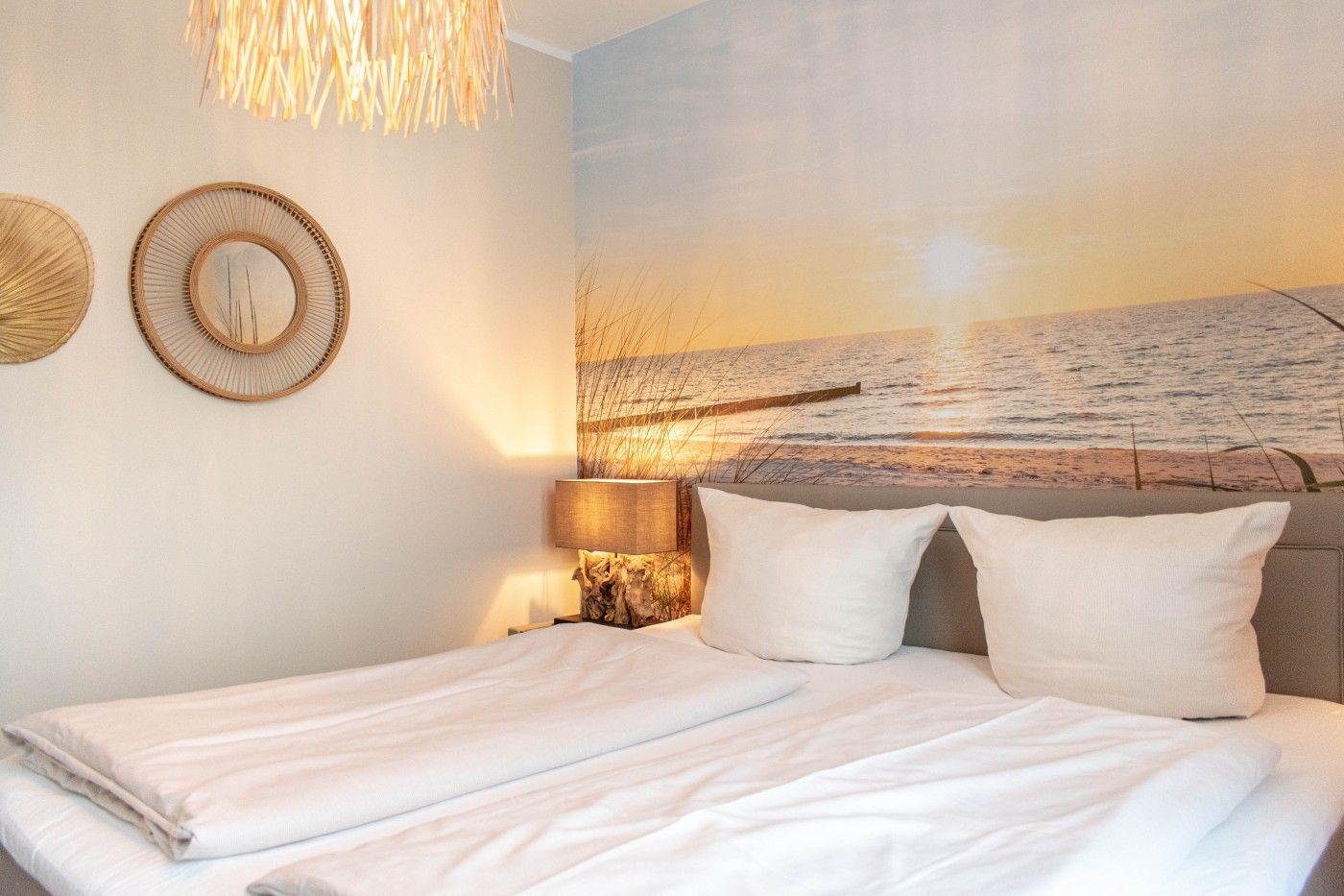 Schlafzimmer mit Bett, Wandbild und Lampe.