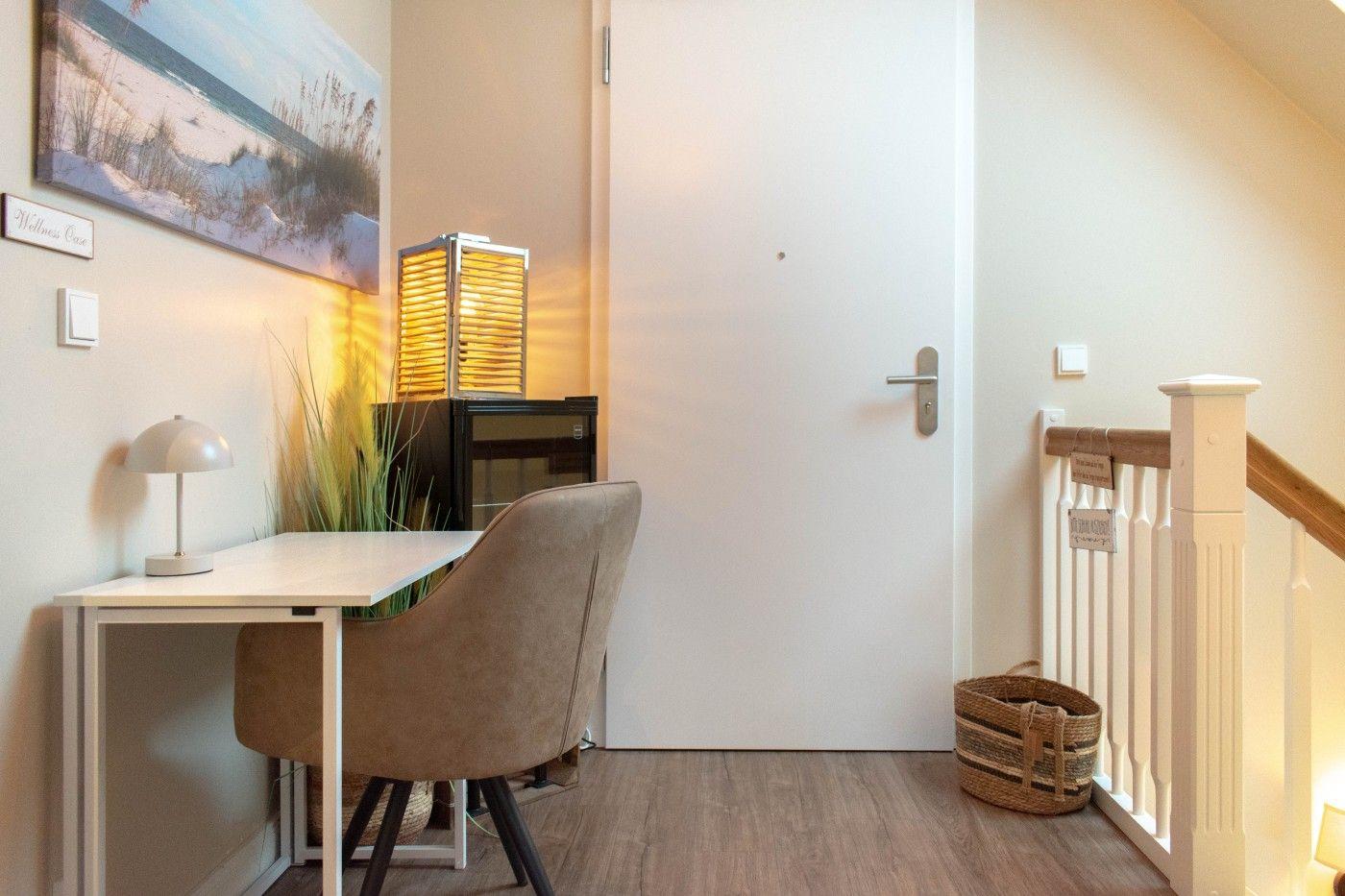 Höhlenartiger Eingangsbereich mit Schreibtisch, Stuhl und Wandbild.