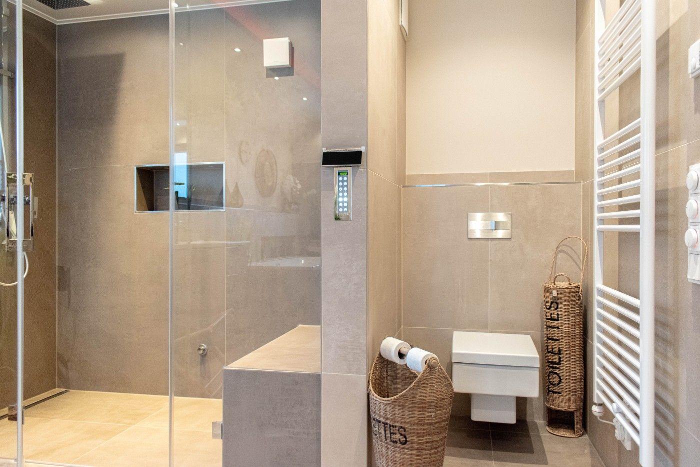 Moderne Dusche mit Glaswand, Toilette und Heizung