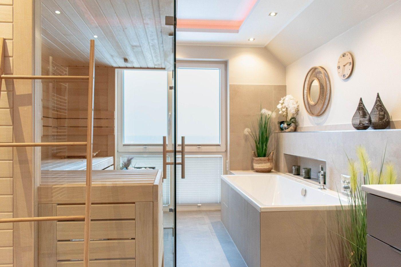 Badezimmer mit Whirlpool und Sauna im Hintergrund.