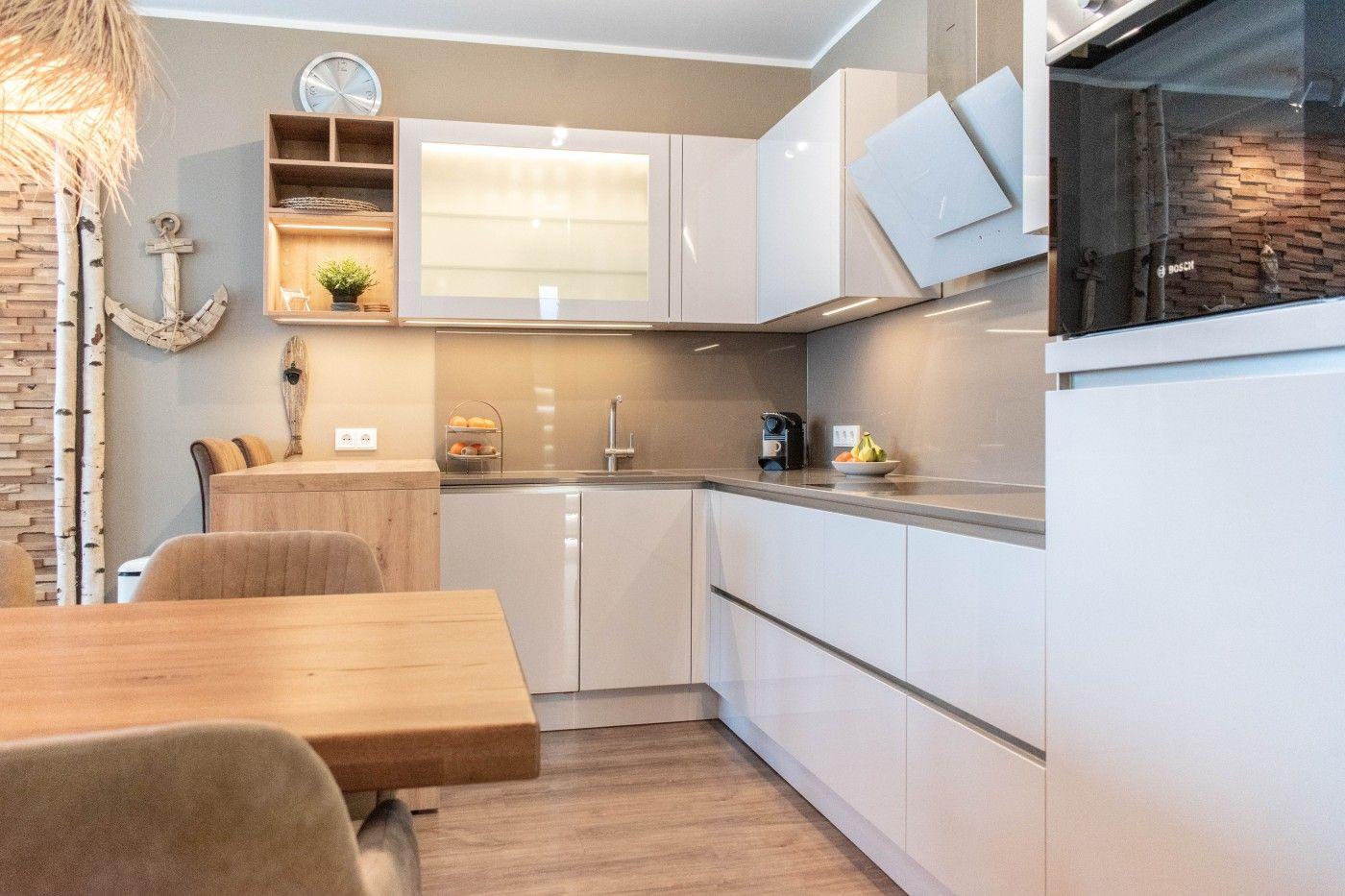 Moderne Küche mit weißen Schränken und Holztisch