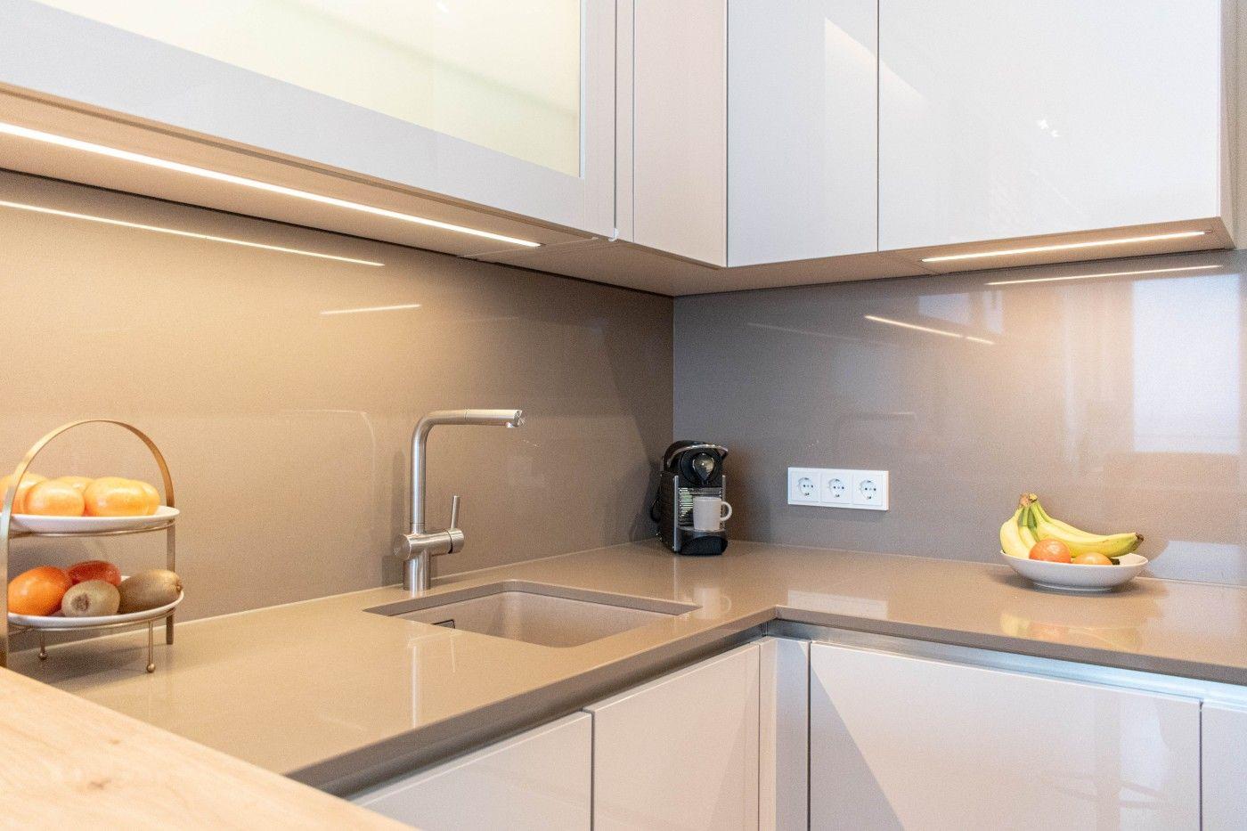 Küche mit Arbeitsplatte, Spüle und Obstschale.