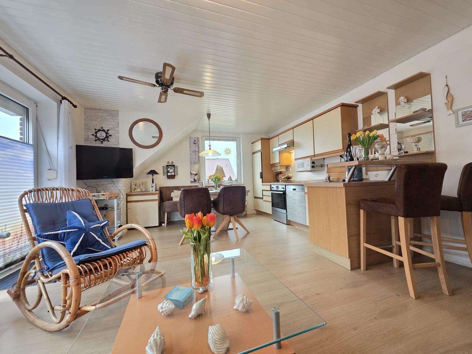 Living and kitchen area with dining table, seating, and kitchen cabinets.
