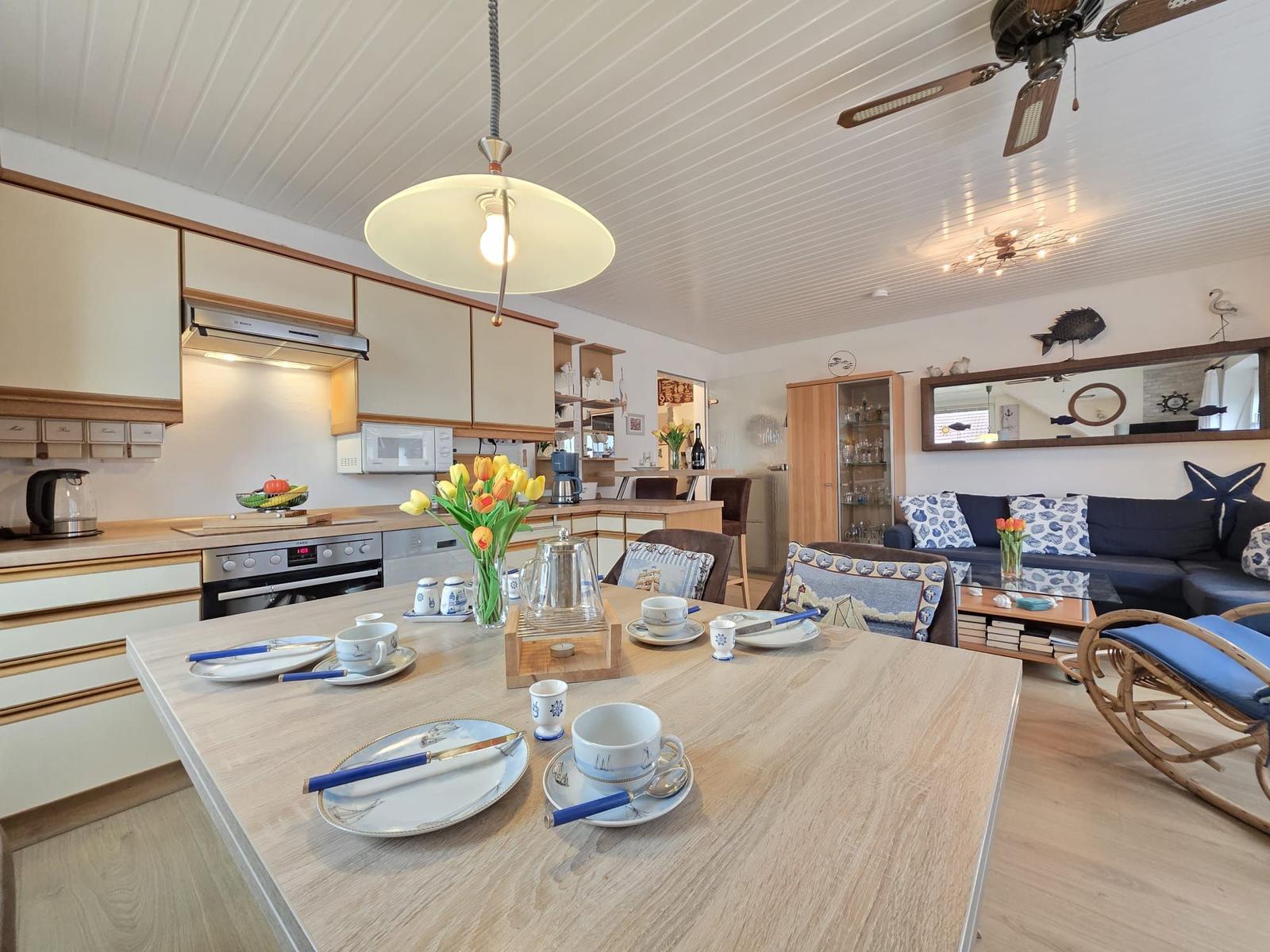 Kitchen and living area with dining table, sofa, and kitchen cabinets.