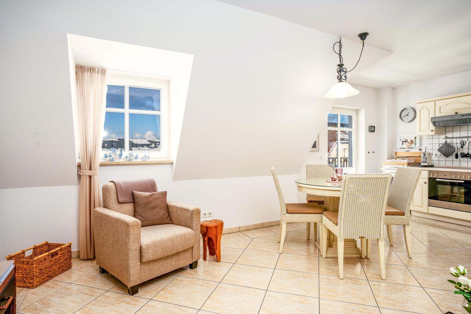 Wohn- und Essbereich mit Sitzgelegenheit, Esstisch und Küche. Fenster mit Blick auf Schnee.