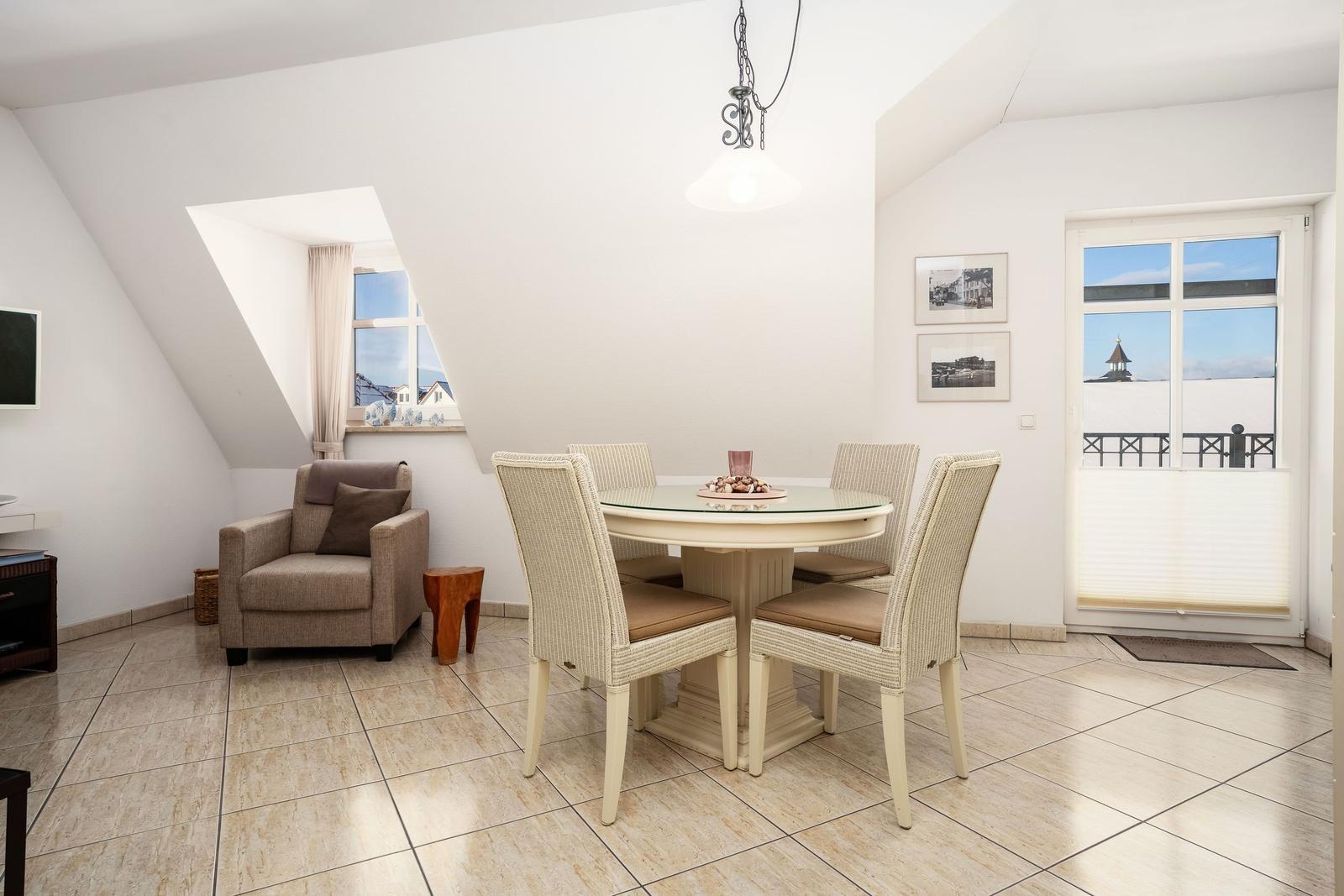 Esszimmer mit runden Tisch, vier Stühlen und Blick auf Balkon.