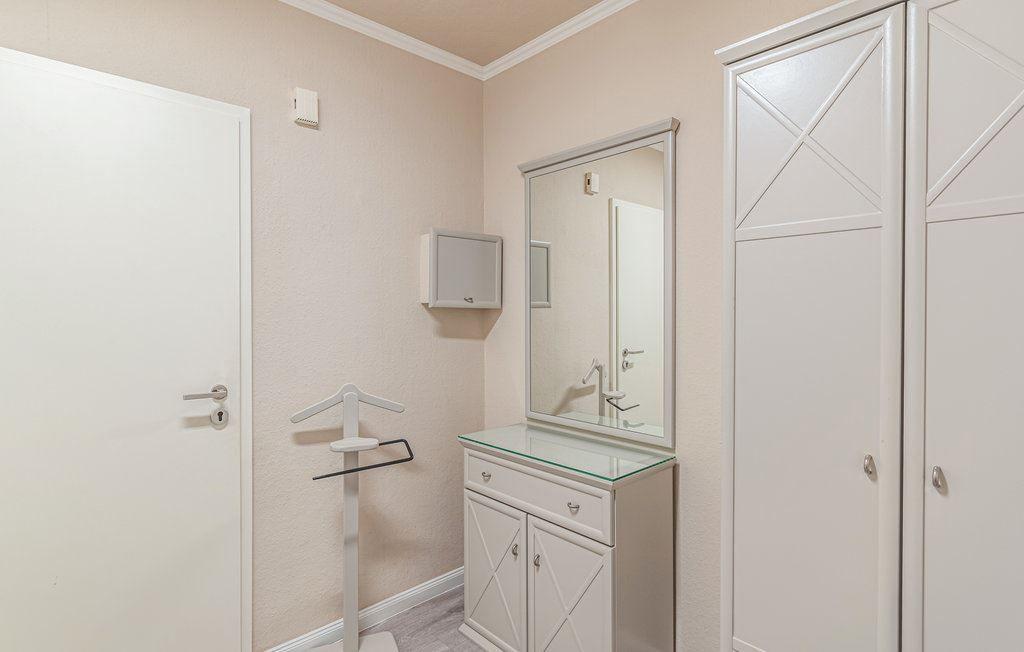 Schlafzimmer mit Kleiderschrank, Spiegelschrank und Kleiderständer.