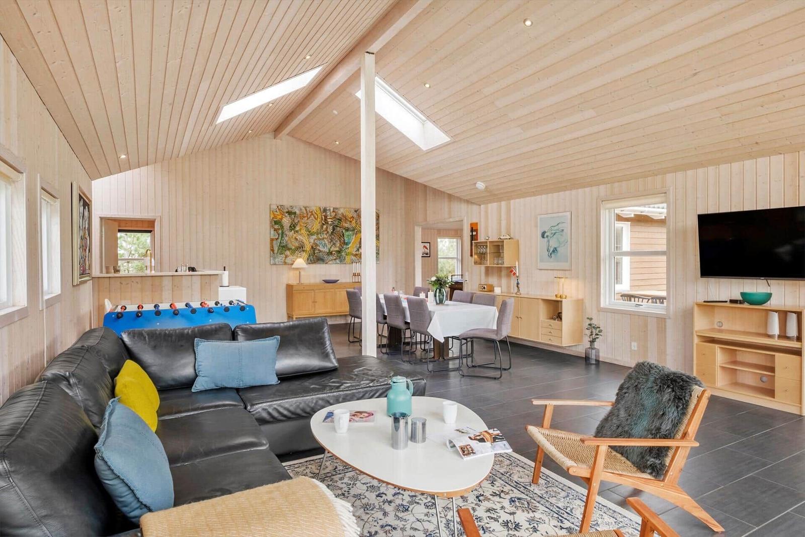 Living and dining area with sofa, table, and TV.