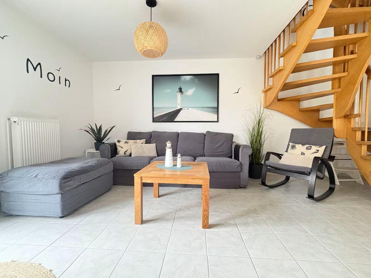Living room with gray sofa, wooden table, and spiral staircase.