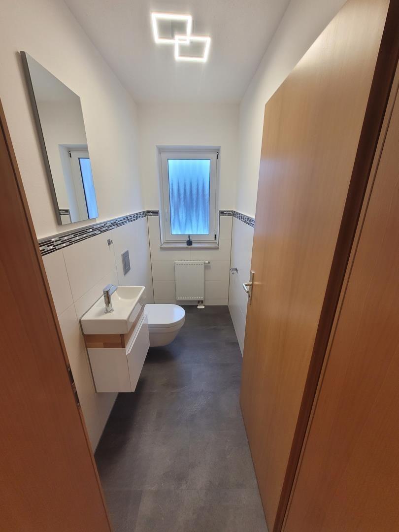 Bathroom with sink, toilet, and window