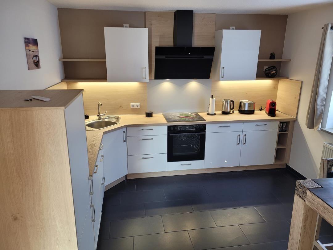 Modern kitchen with worktop, sink, stove, and extractor hood.