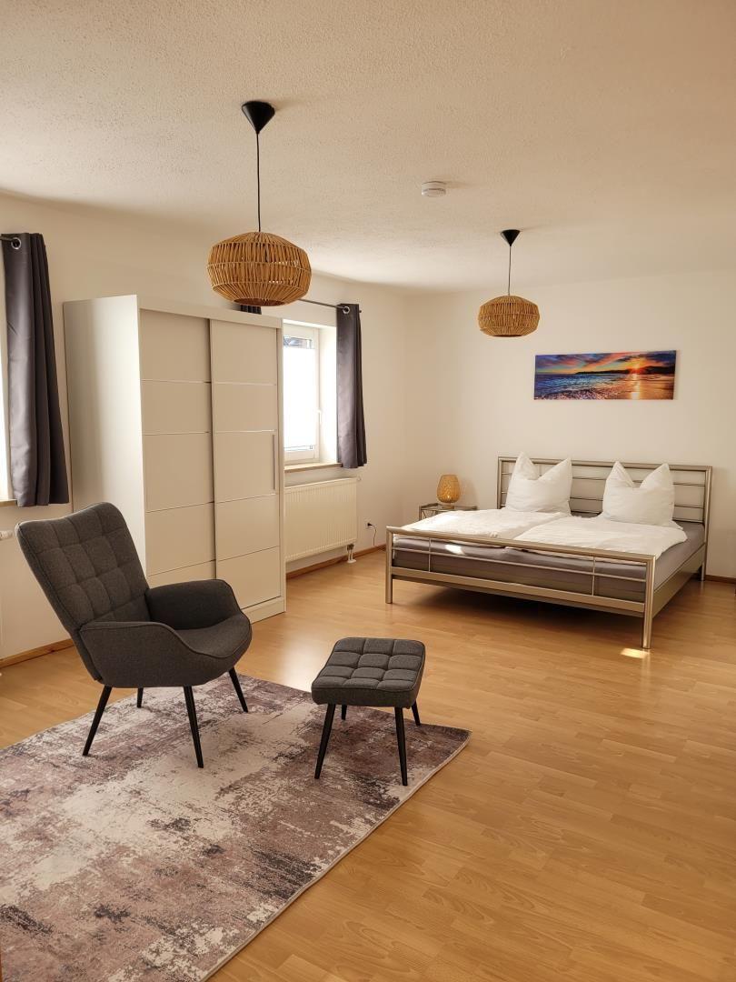Bedroom with bed, armchair, and wall art