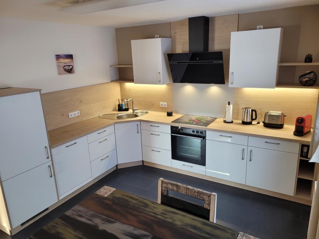 Kitchen with white cabinets, wooden surfaces, and built-in oven.