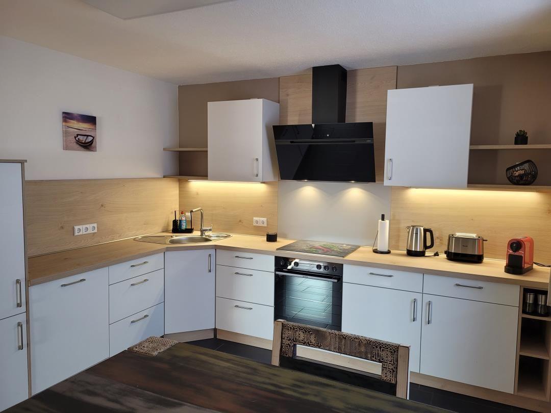 Kitchen with white cabinets, wooden countertop, and built-in stove.