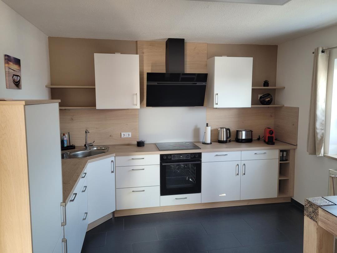 Kitchen with white cabinets, wood finish, and stainless steel sink.