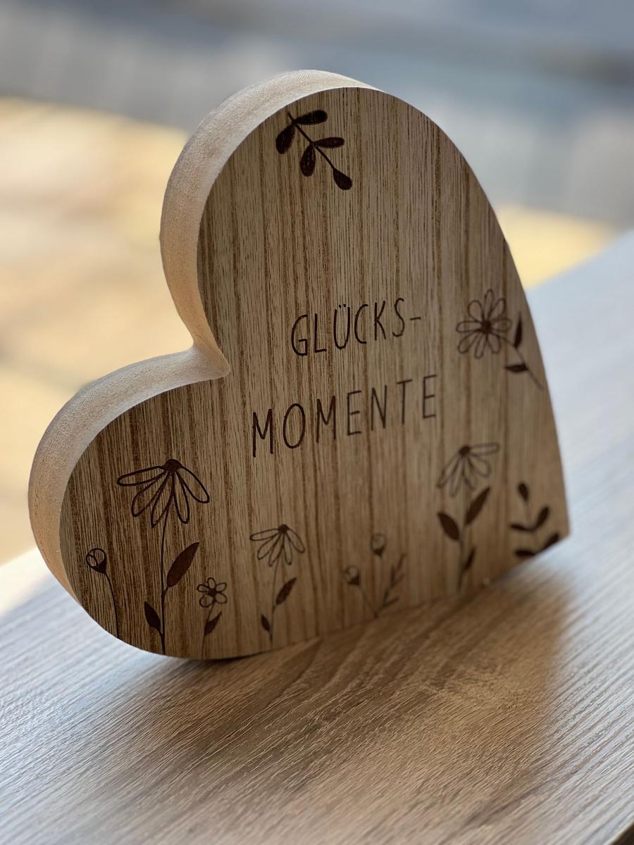 Holzherz mit Gravur Glücks-Momente und Blumenmotiven auf Tisch