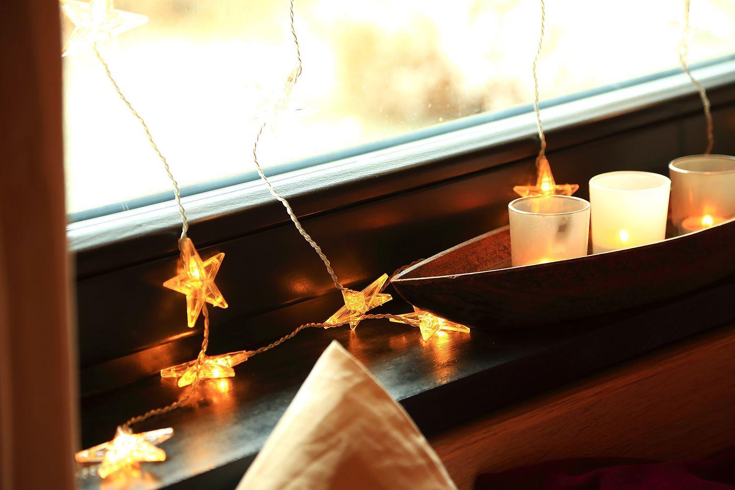 Fensterbank mit Kerzen und Sternenlichterkette