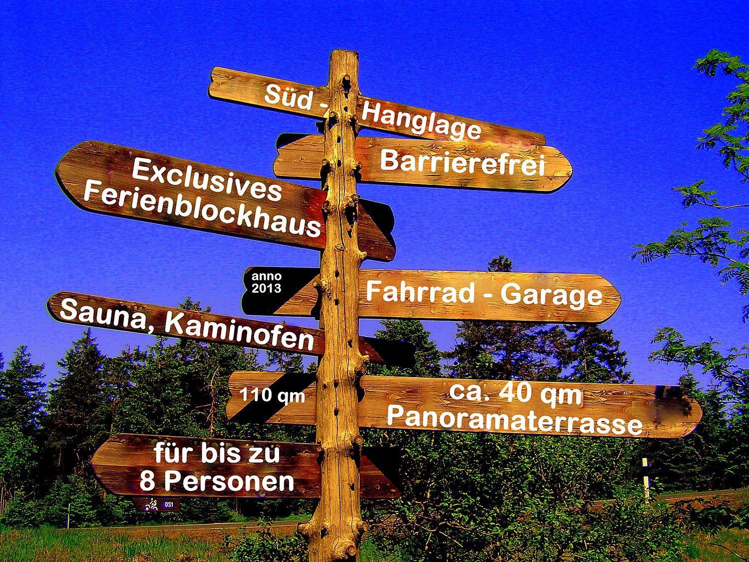 Holzschild weist auf exklusives Ferienhaus mit Sauna, Garage und Panoramaterrasse hin.