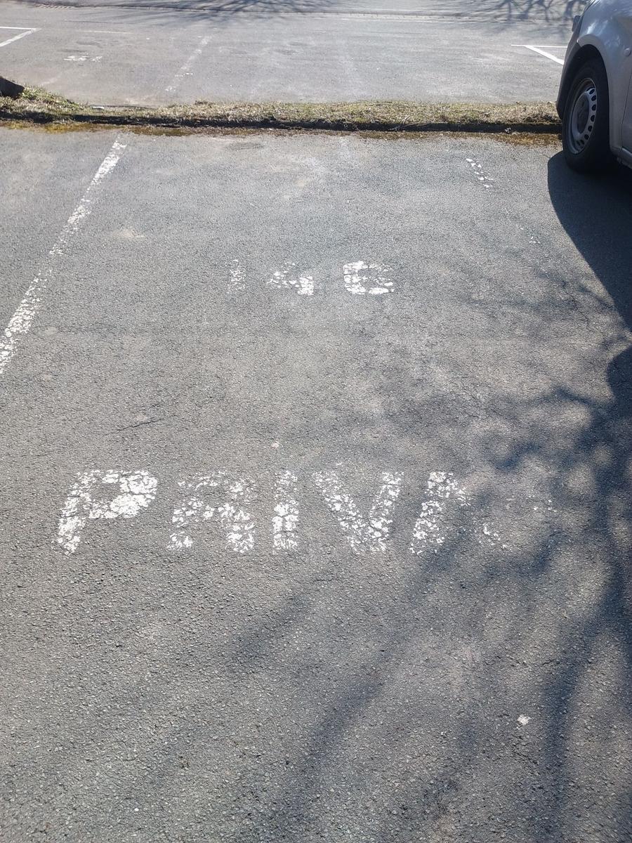 Parkplatz mit Markierung 148 und dem Wort PRIVAT auf Asphalt
