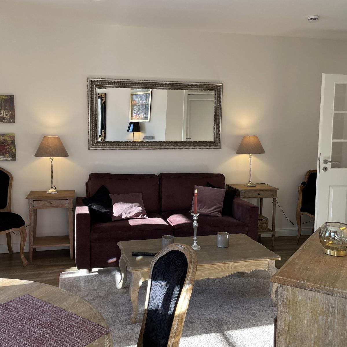 Ein Wohnzimmer mit einem Sofa, einem Tisch und zwei Lampen.