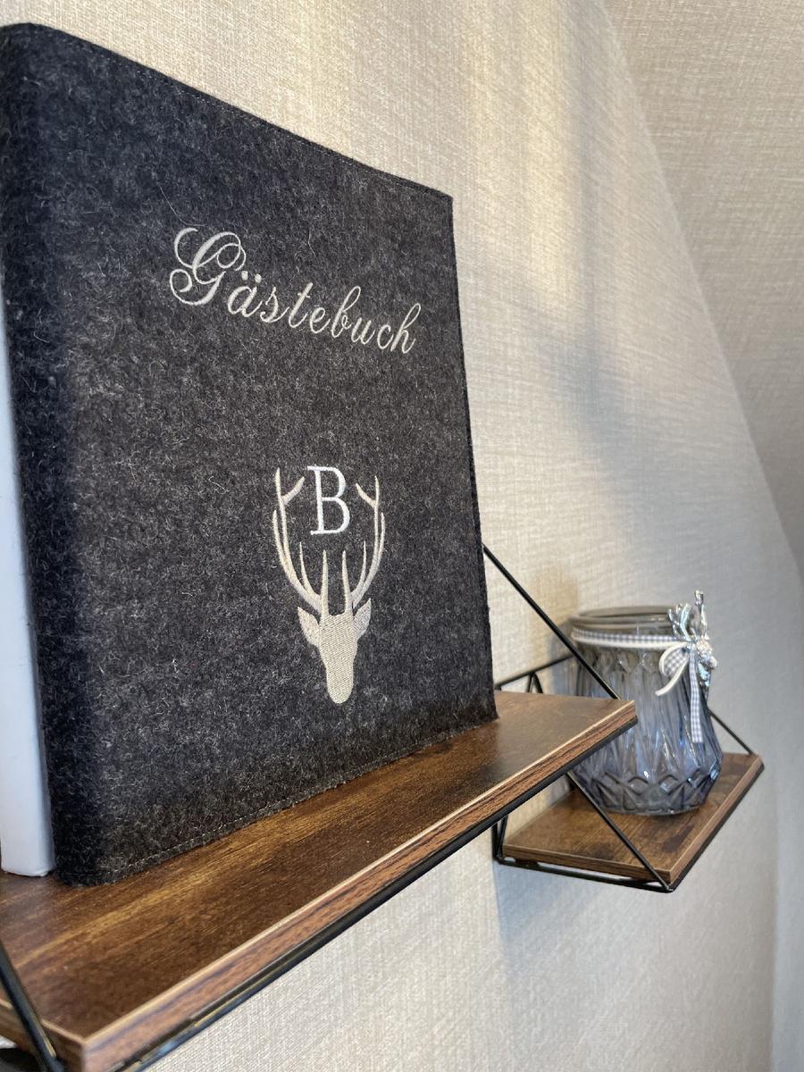 Gästebuch mit Hirschmotiv und Buchstabe B auf Holzregal