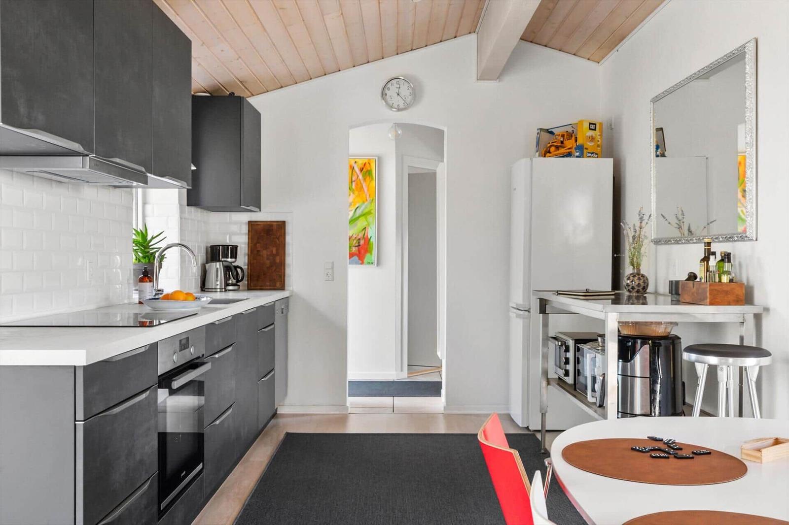 Kitchen with worktop, fridge, and dining table with chairs.