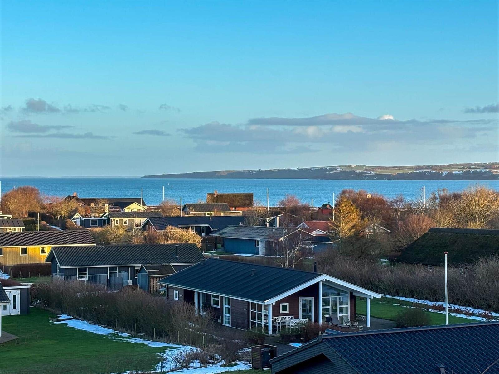 Haus mit Blick auf Meer und Küstenlandschaft. Garten und Terrasse mit Sitzmöbeln.