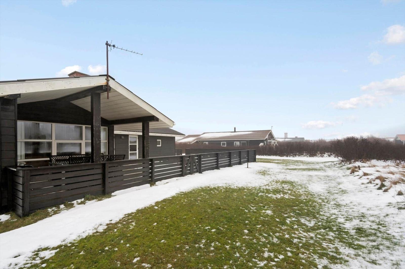 Haus mit Terrasse und Schneebedecktem Grundstück