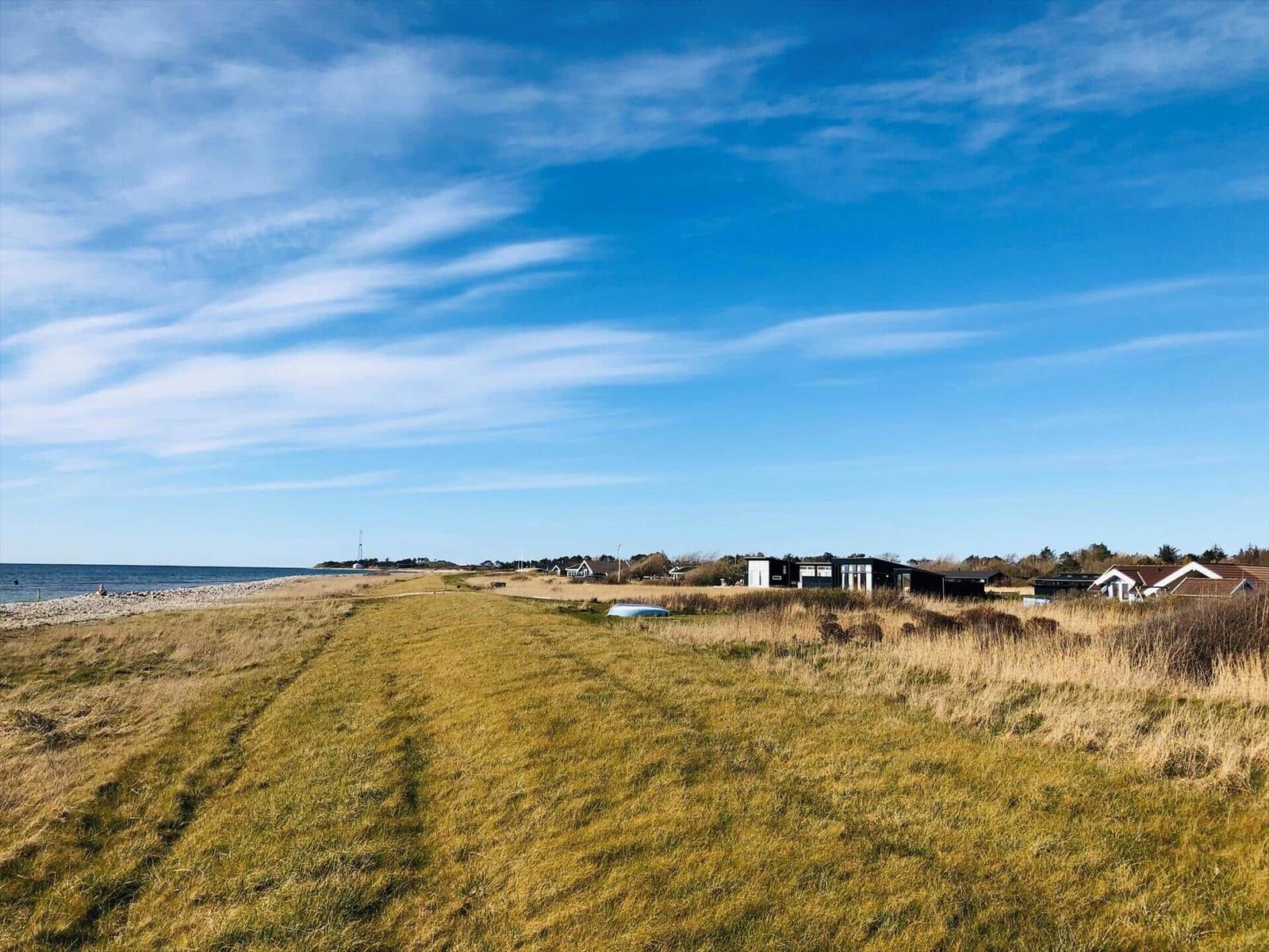 Strandnahe Ferienwohnung mit Blick aufs Meer und grünen Hang.