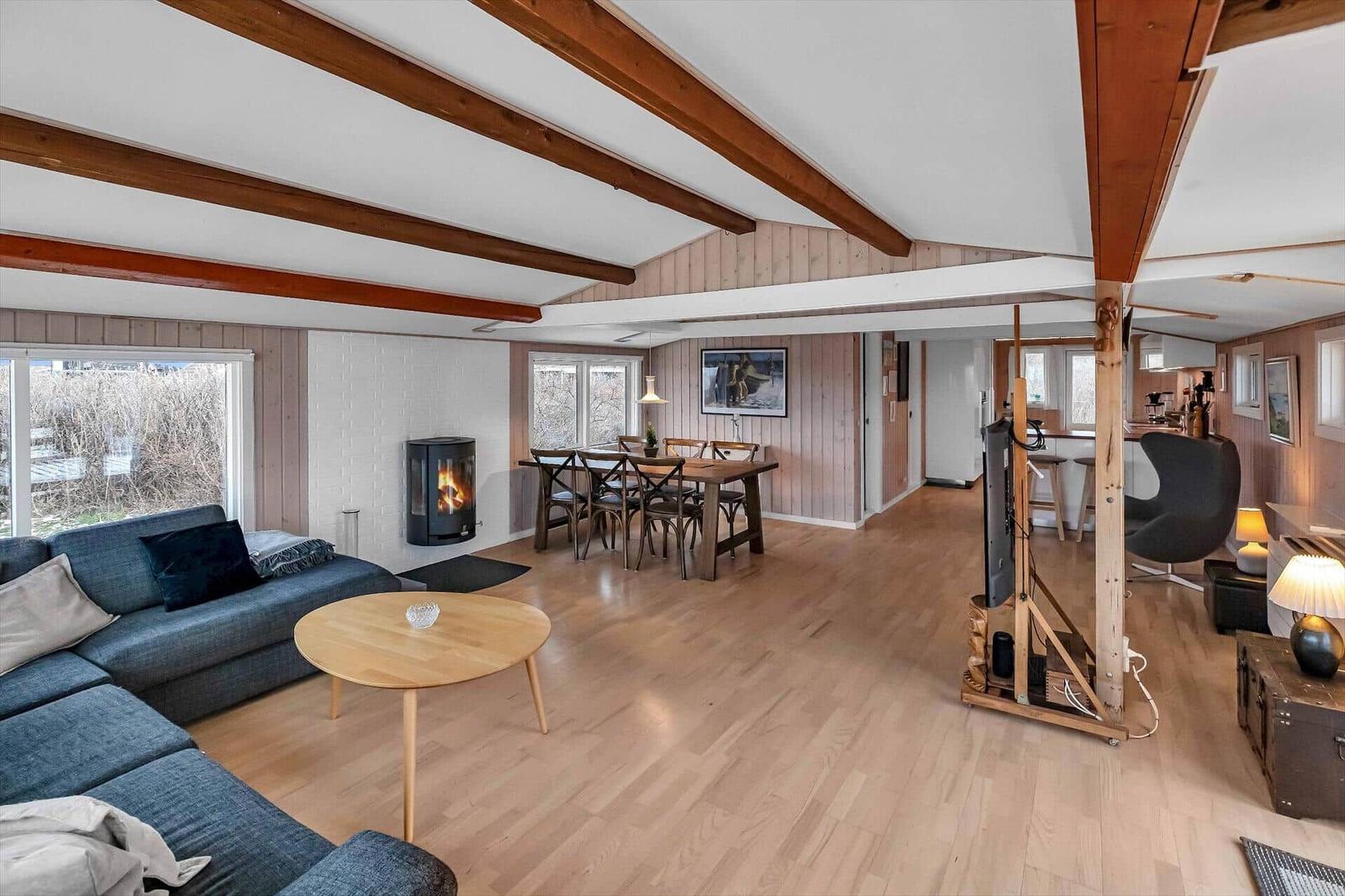 Wohn- und Essbereich mit Holzboden, Kamin und Esstisch.