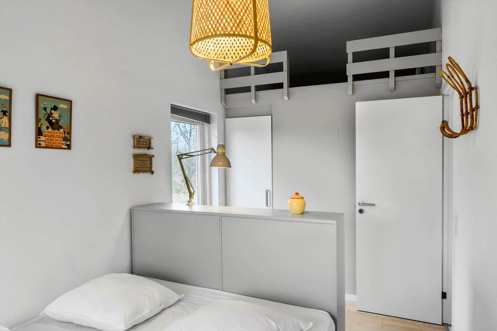 Bedroom with bed, wall art, desk, and loft bed.