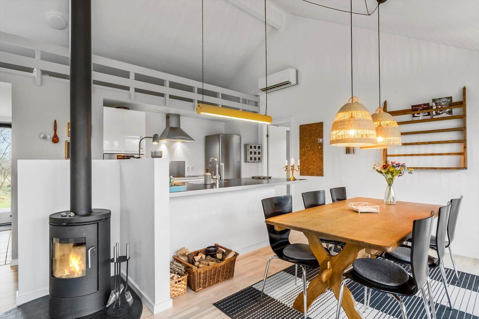 Kitchen with dining area, wooden table, chairs, and wood stove.