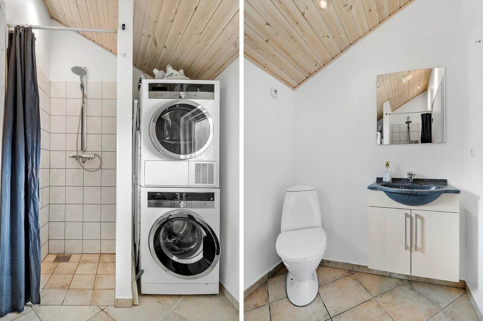 Bathroom with shower, washing machine and dryer, toilet and sink.