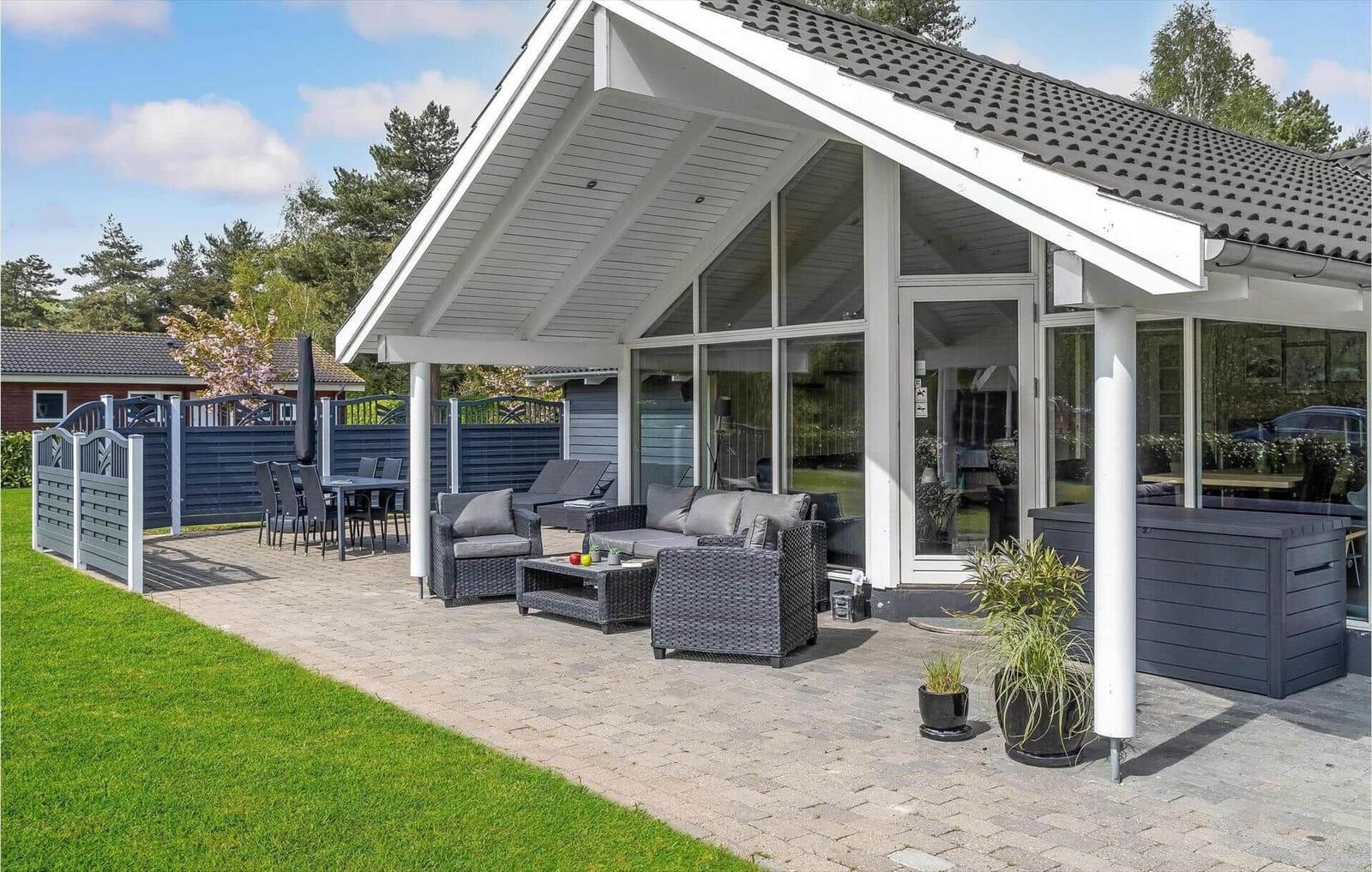 Terrace with seating, table, and hot tub under roof