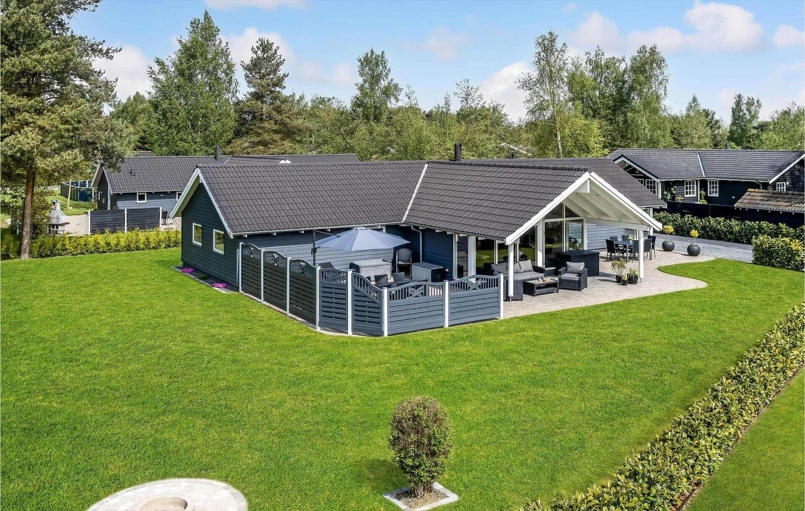 Modern vacation home with large garden and terrace with seating areas.