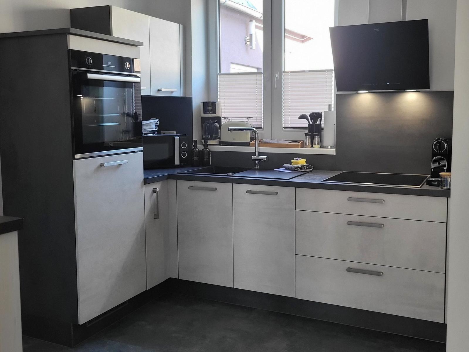 Moderne Küche mit Edelstahlspüle und integriertem Backofen.