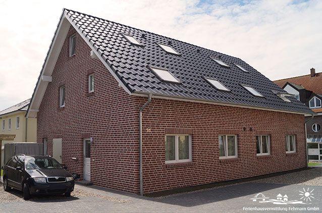 Two-story brick house with skylights and paved yard.