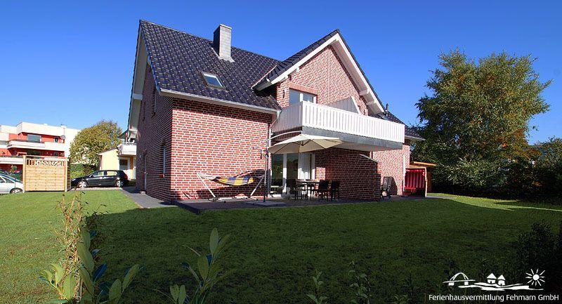 Red brick house with balcony, terrace, and garden. Hammock seating area.
