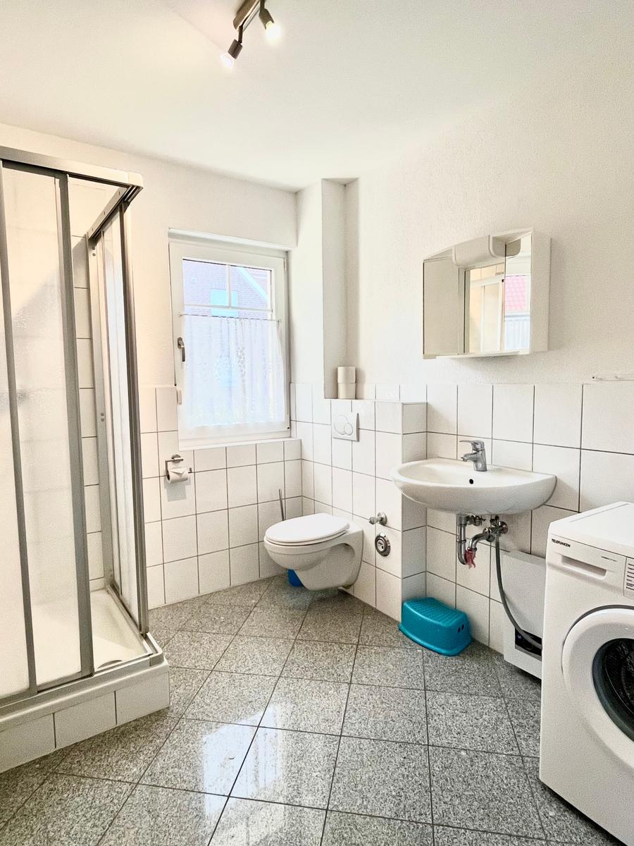 Badezimmer mit Dusche, WC Waschbecken und Waschmaschine