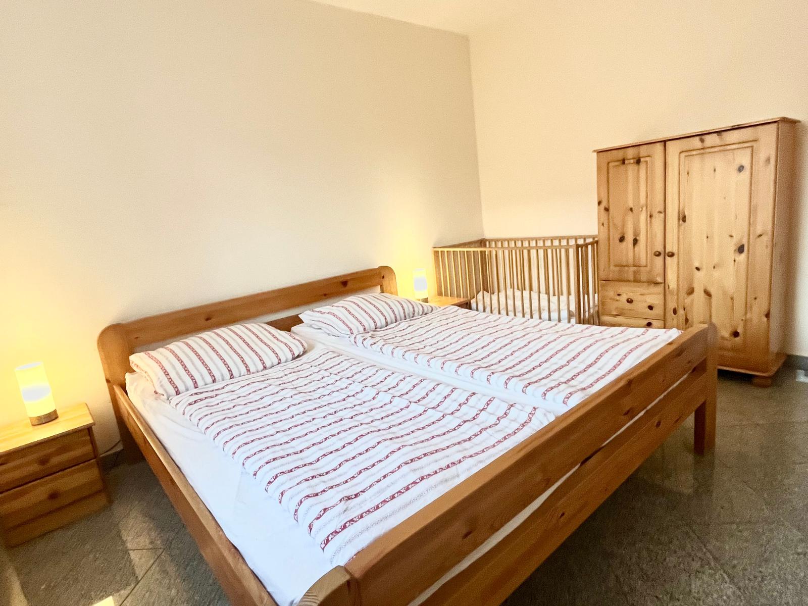 Das erste Schlafzimmer mit Ehebett, Kinderbett und Kleiderschrank