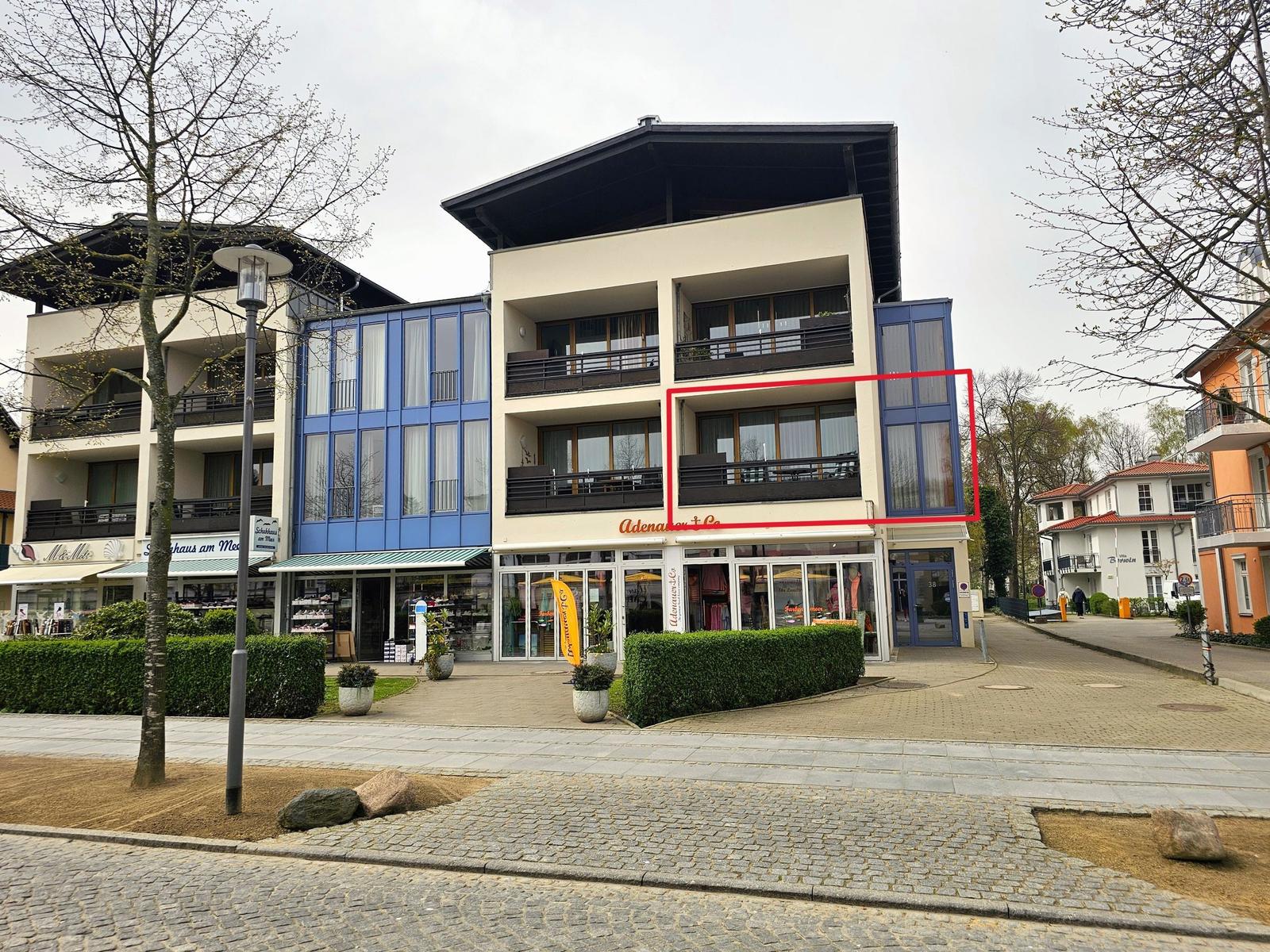 Ferienwohnung mit Balkon und großen Fenstern im modernen Gebäude.
